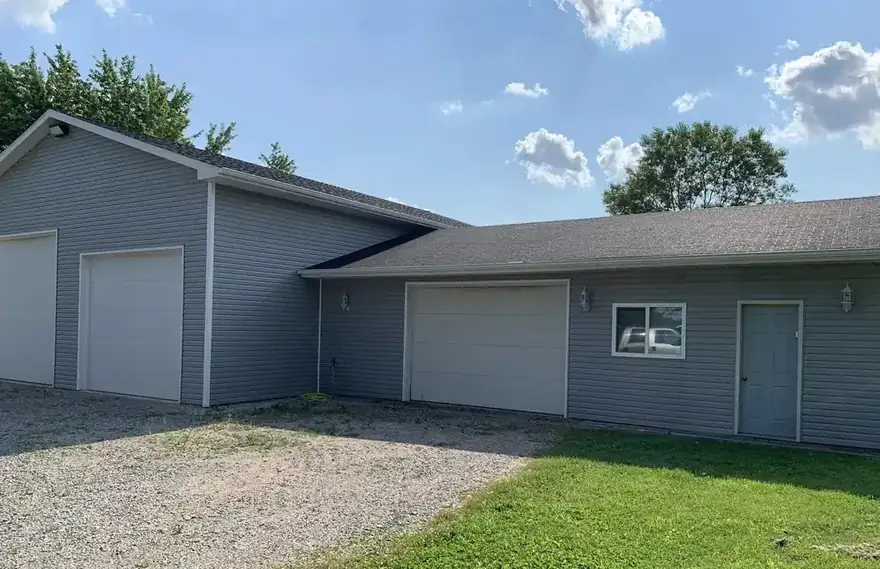 Gray-sided house and detached garage with new gutters and downspouts