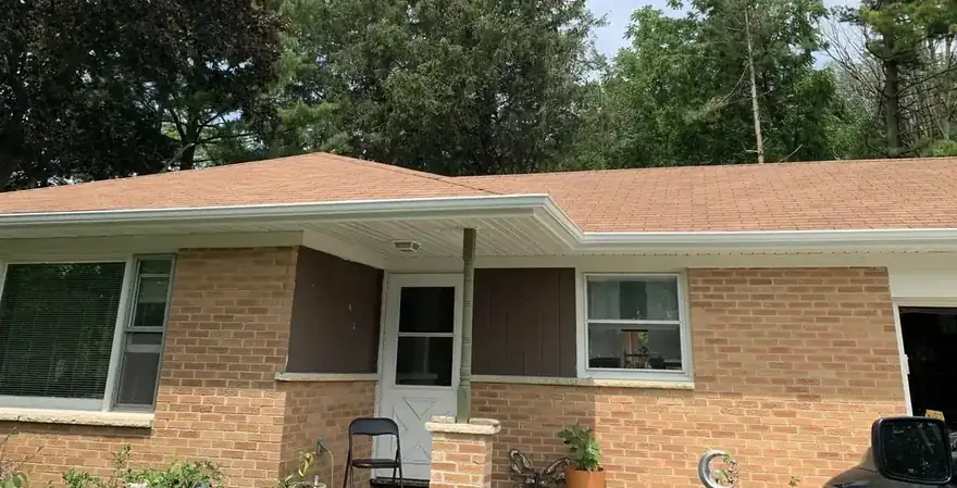 Brick ranch house with a long white gutter run along the eave