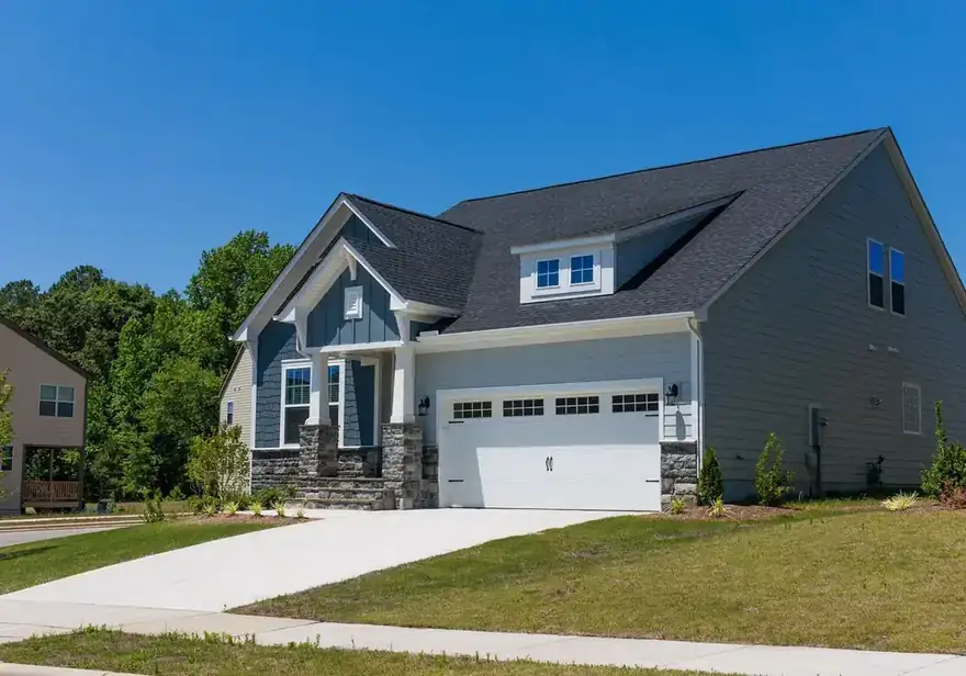 Craftsman house with dormers, stone columns and white gutters