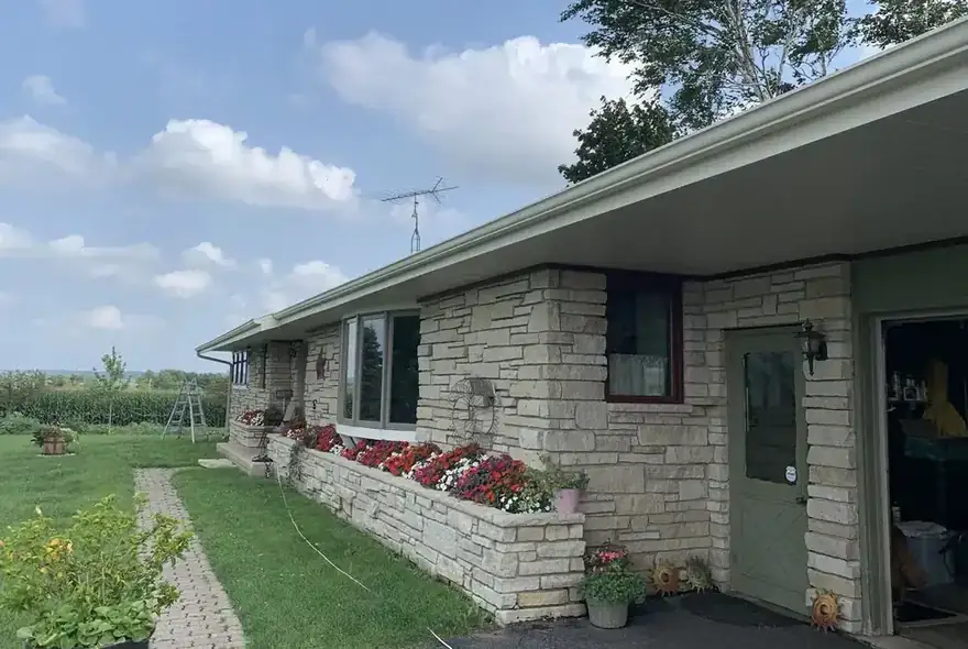 Stone ranch house with a long gutter run under a wide soffit