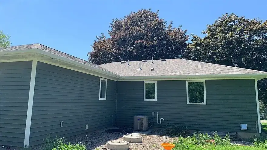 Teal sided house with gutters along the roof edge