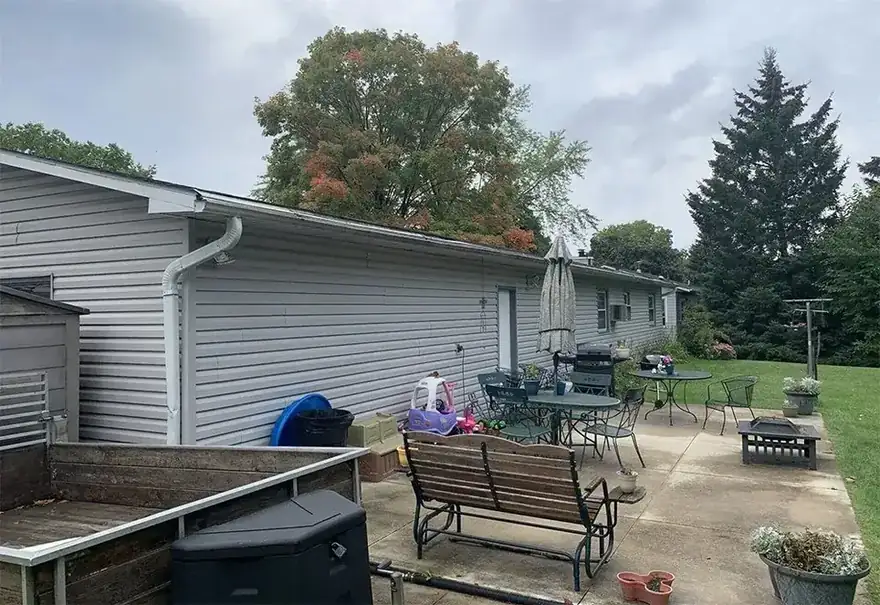 Gray sided house wall with patio furniture in front of it