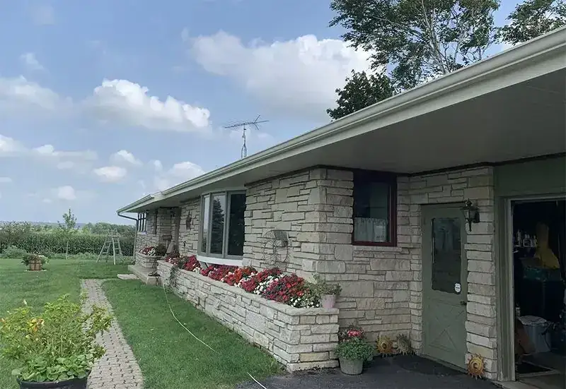 Stone ranch house with a flower box under the front window